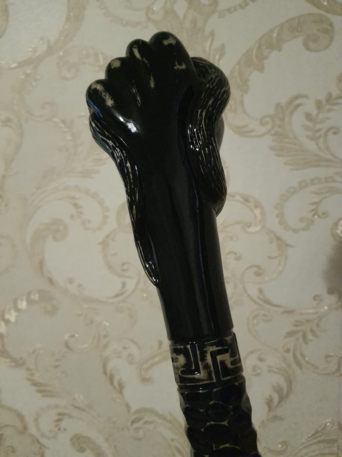 A carved wooden stick with a fist handle