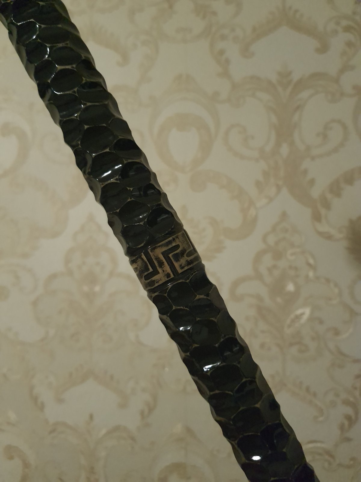 A carved wooden stick with a fist handle