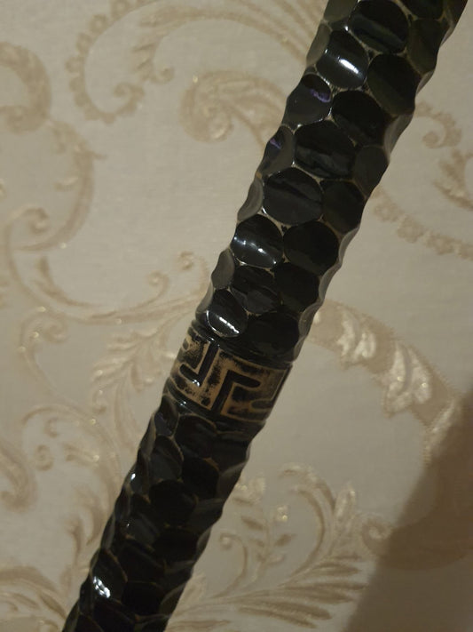 A carved wooden stick with a fist handle