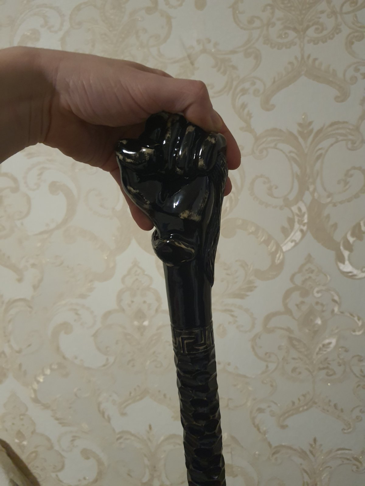 A carved wooden stick with a fist handle