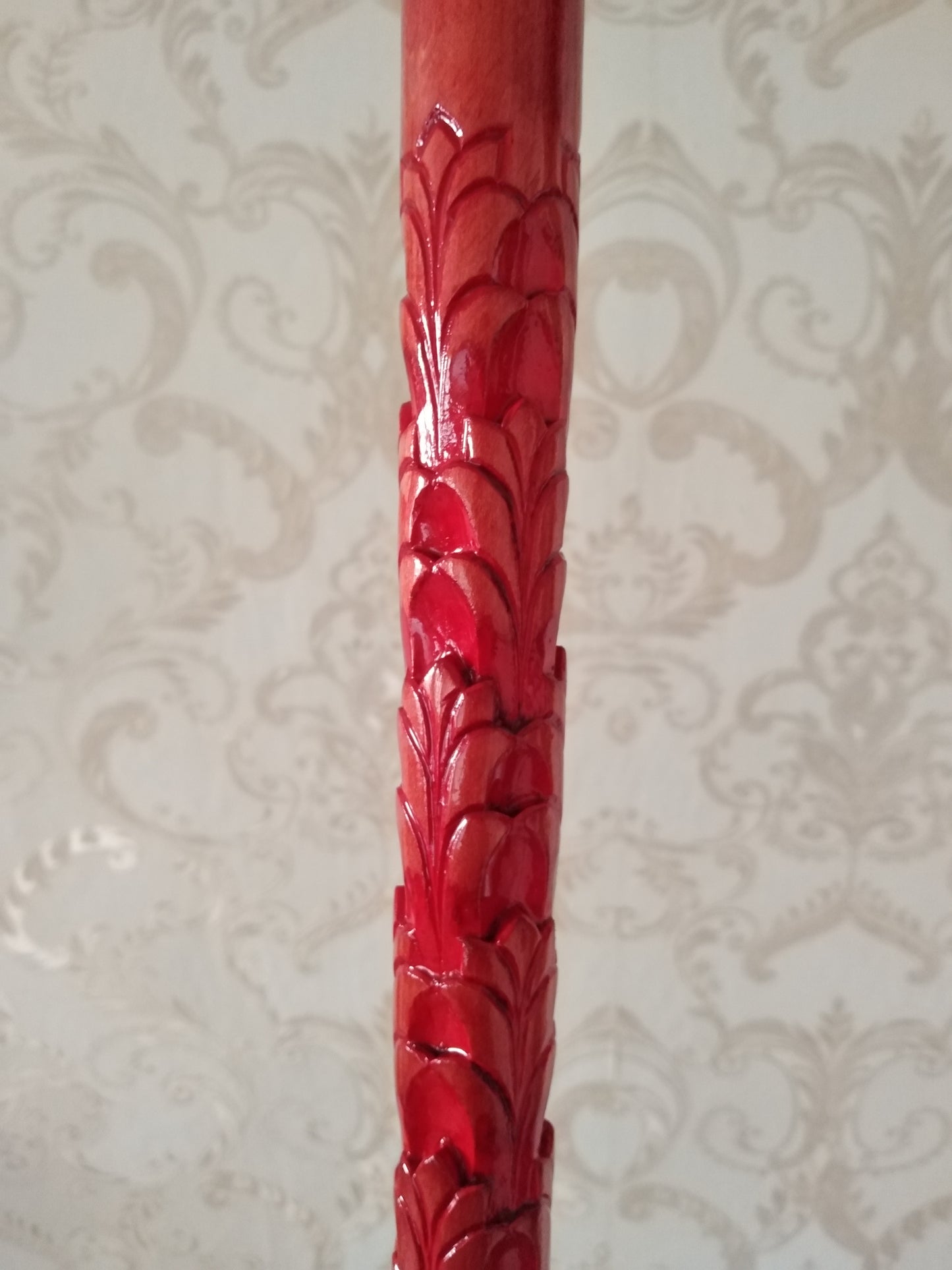 A carved wooden stick with a leaf pattern