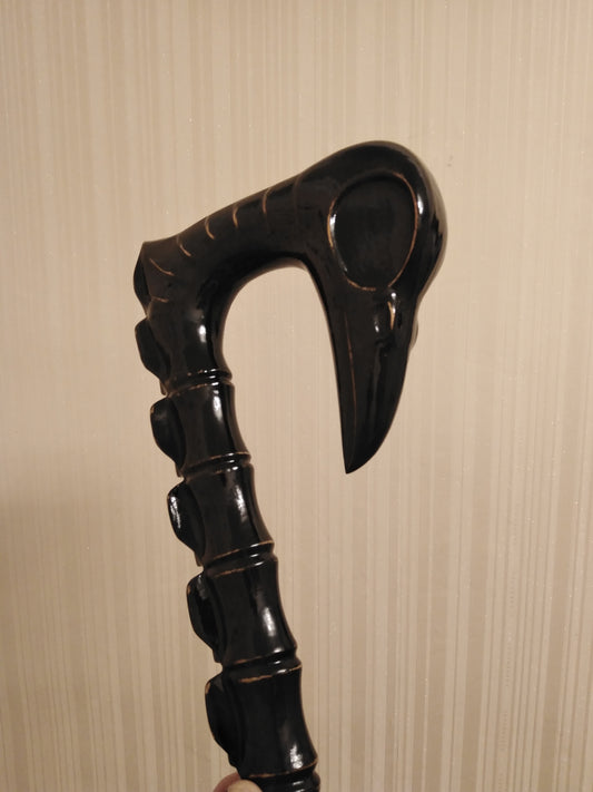 Carved wooden cane in the form of a spine with a crow's skull